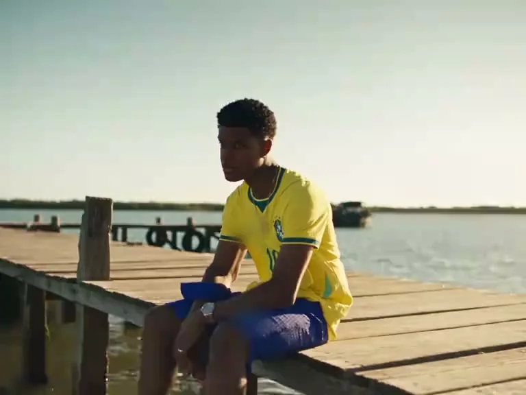 Character A seated on the pier in the opening